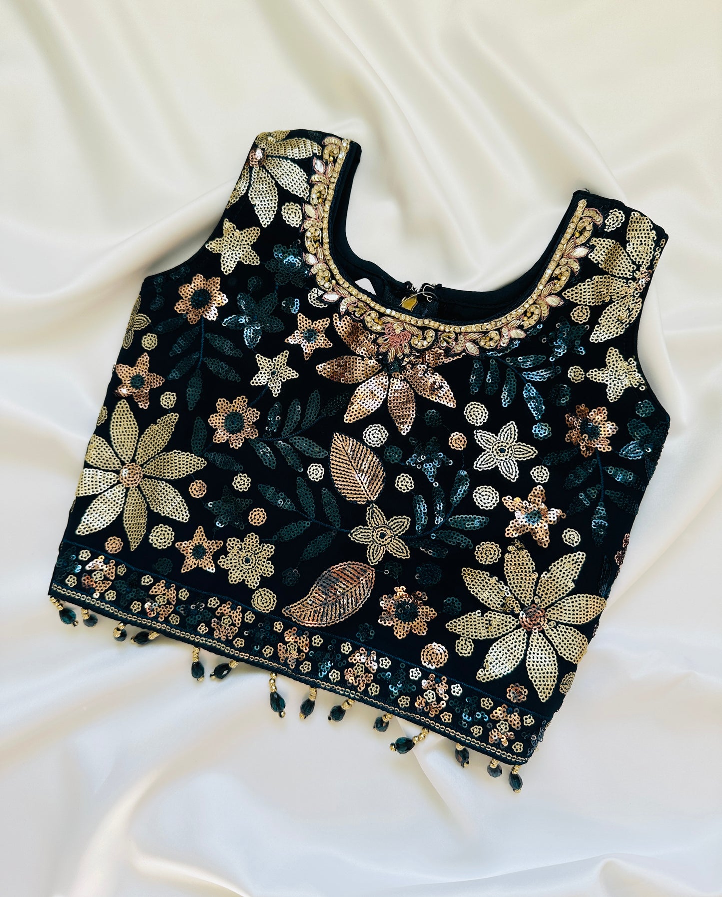 Black embroidered top with gold flowers on a white background